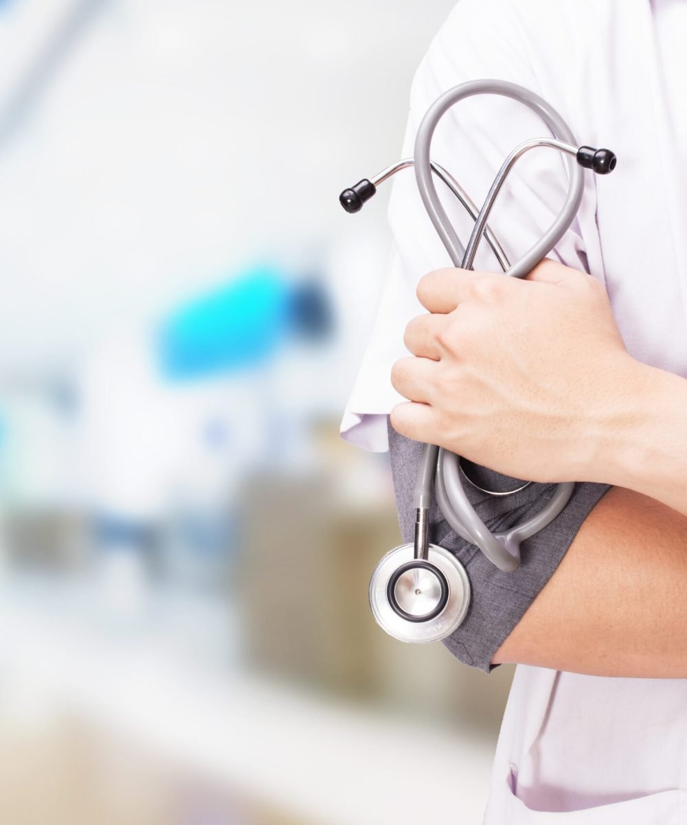 Doctor with a stethoscope in the hands and hospital background.